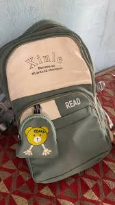 casual olive green and cream backpack featuring a cute little bear pouch clipped to the front pocket.