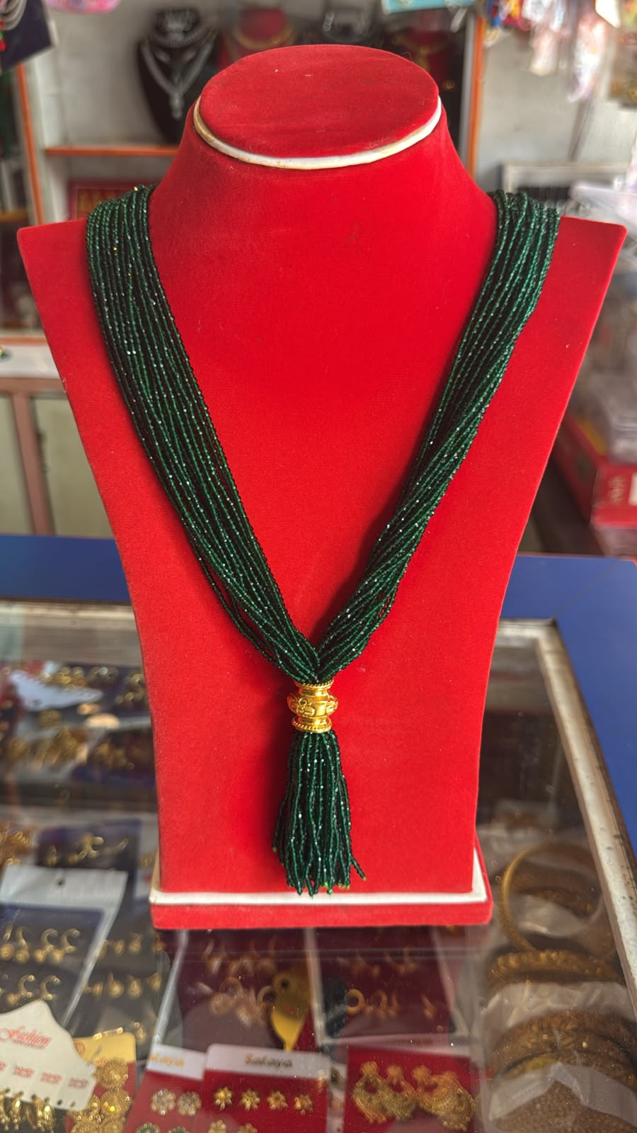 traditional multi-strand green hydro pote necklace featuring an ornate gold-accented gedi or tilhari pendant