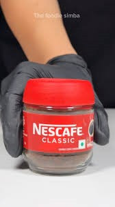 Nescafé Classic soluble coffee powder featuring a distinct bright red plastic lid and label.